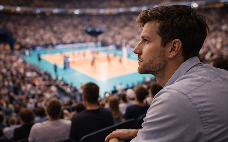 Spettatore che segue attentamente una partita di volley dal vivo